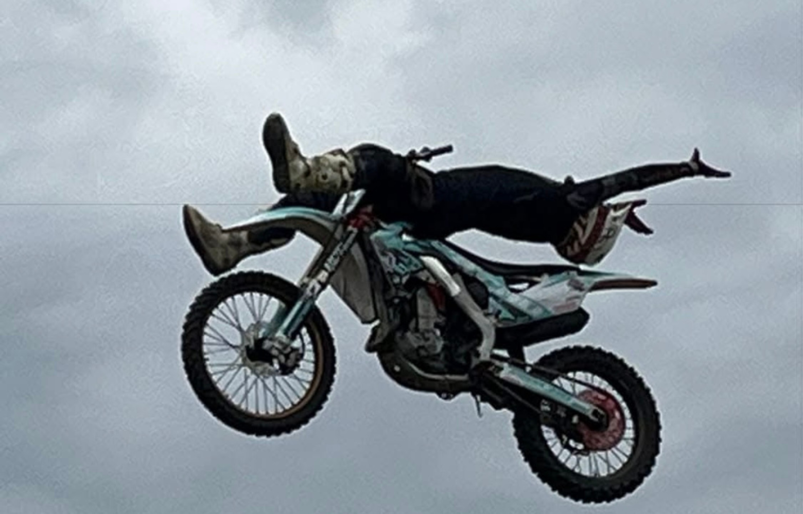 A high-energy FMX stunt, showcasing a rider soaring through the air while executing an adrenaline-pumping freestyle motocross trick.