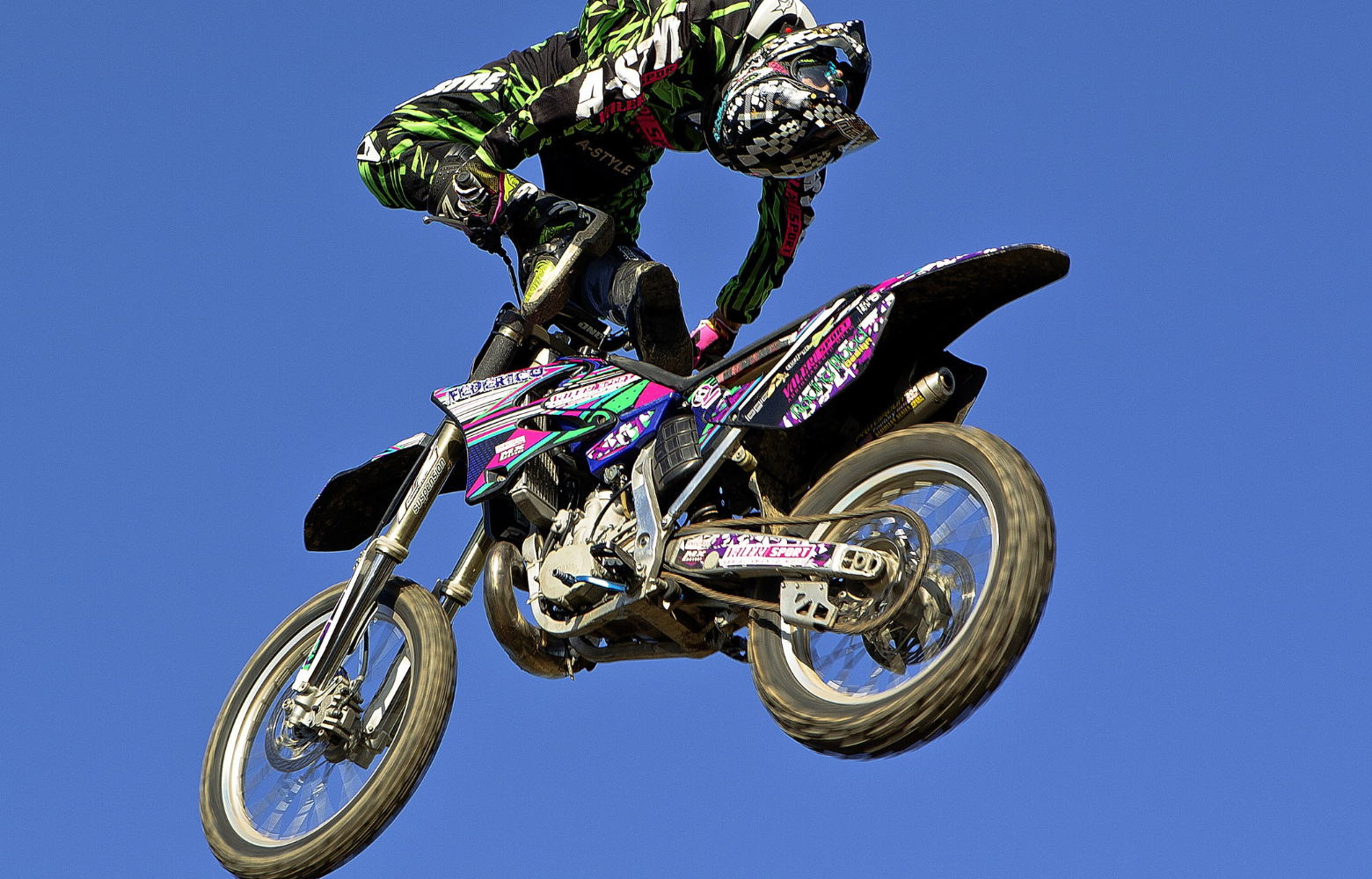 A high-energy FMX stunt, showcasing a rider soaring through the air while executing an adrenaline-pumping freestyle motocross trick.