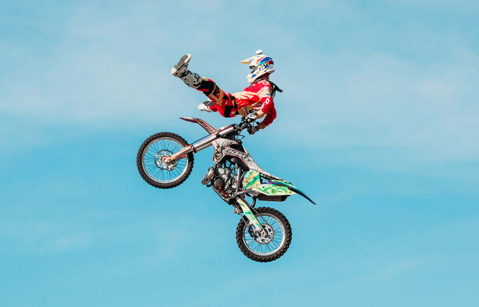 A high-energy FMX stunt, showcasing a rider soaring through the air while executing an adrenaline-pumping freestyle motocross trick.