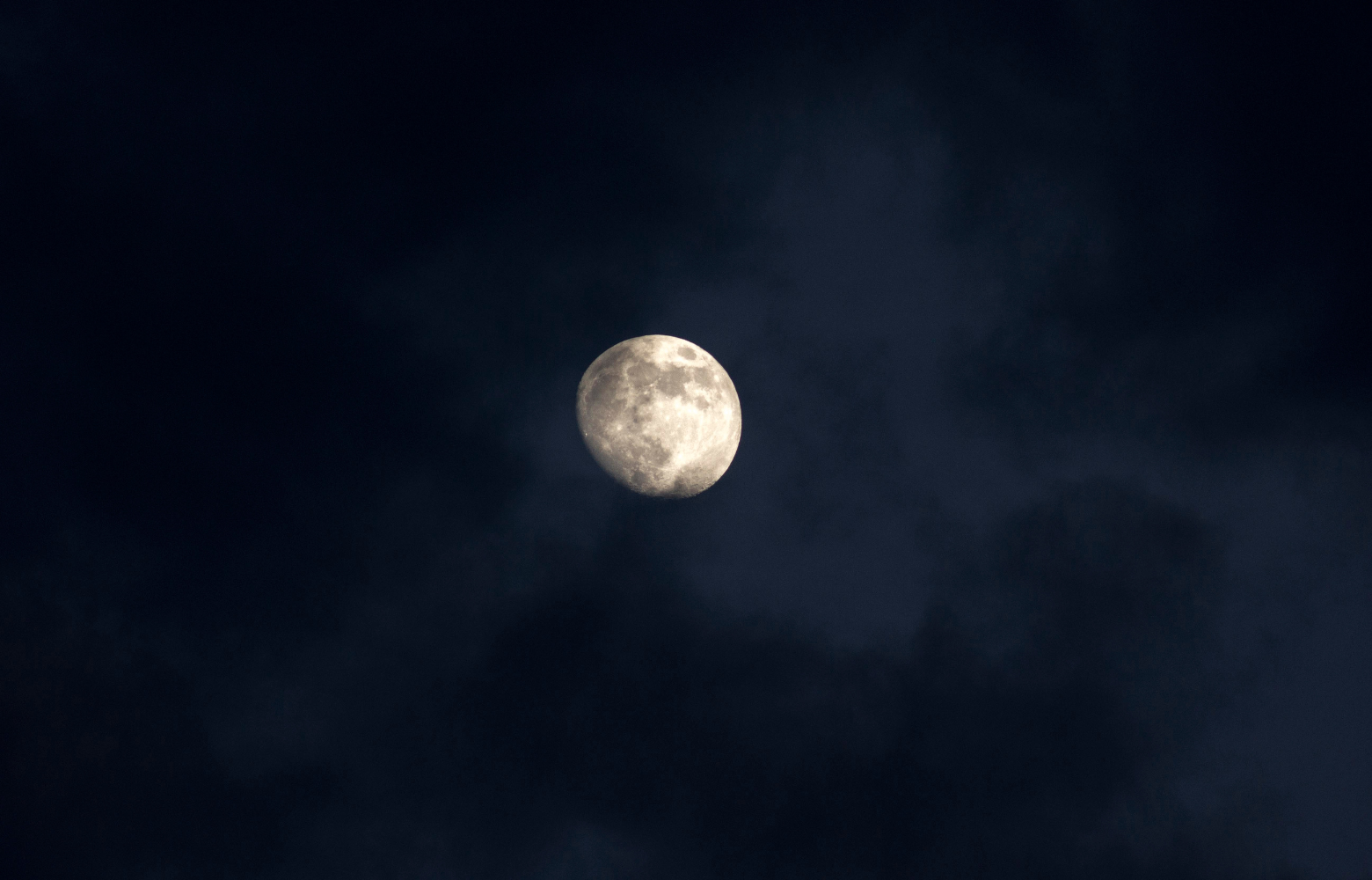A glowing moon in the night sky, setting a mysterious and eerie tone for haunted hay rides.