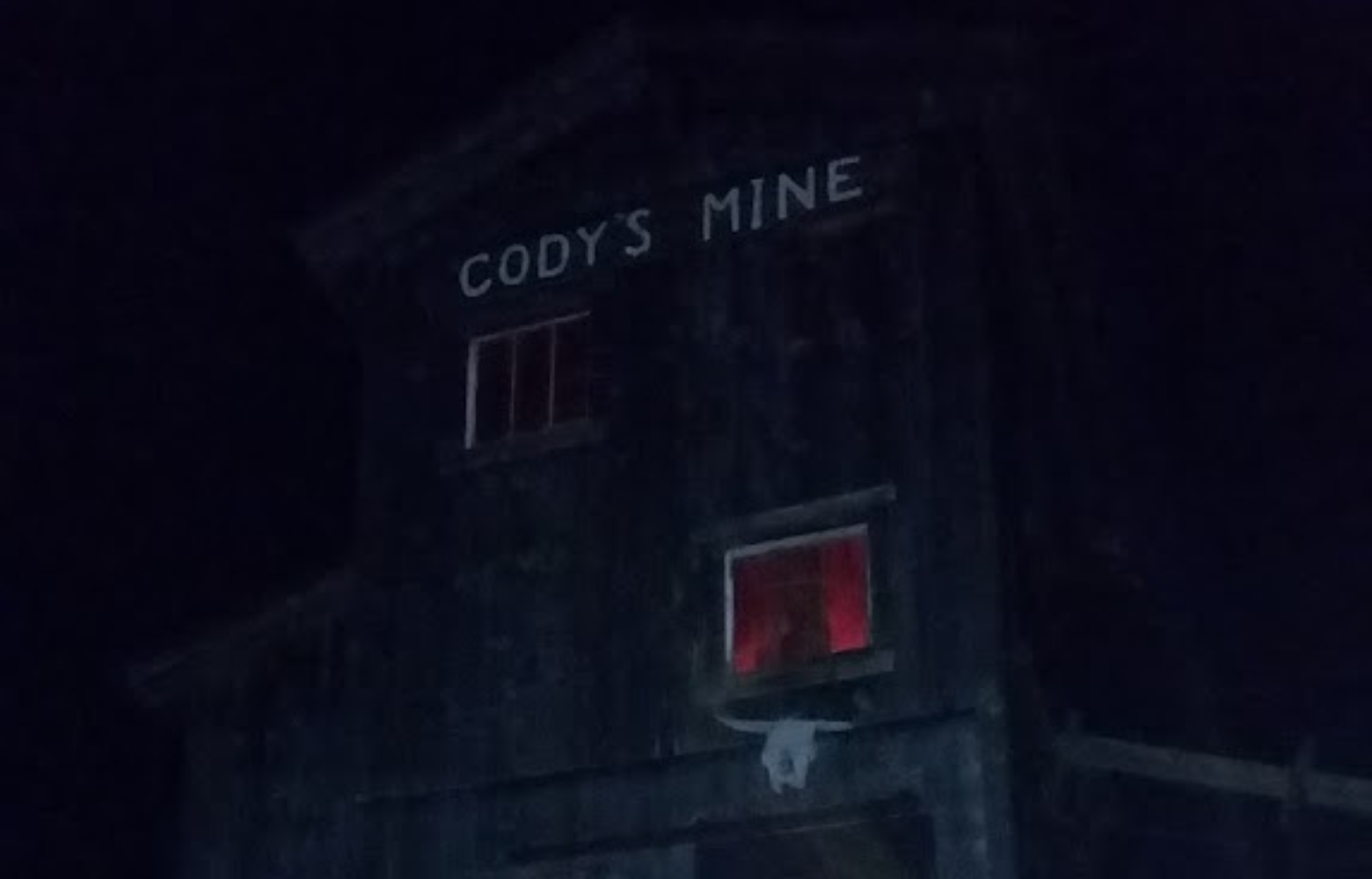 A photo of Cody’s Mine illuminated from within, creating a spooky, Halloween-themed glow.