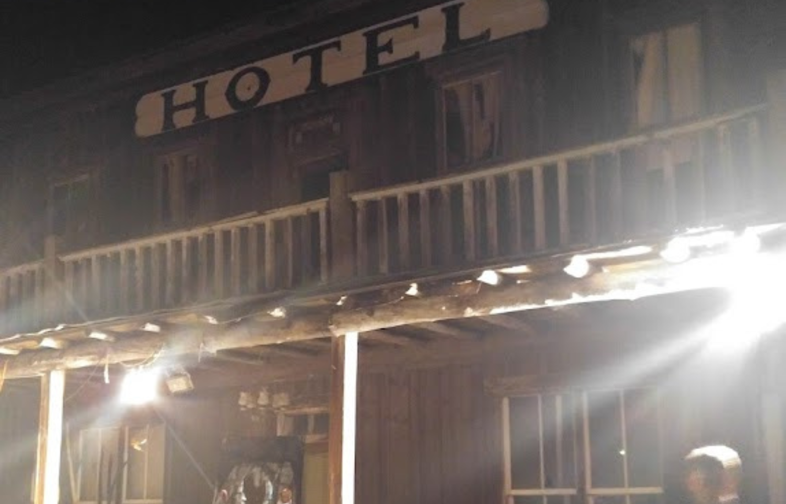 An old traditional hotel decorated for haunted hay rides, with eerie lighting and festive Halloween decor creating a spooky atmosphere.