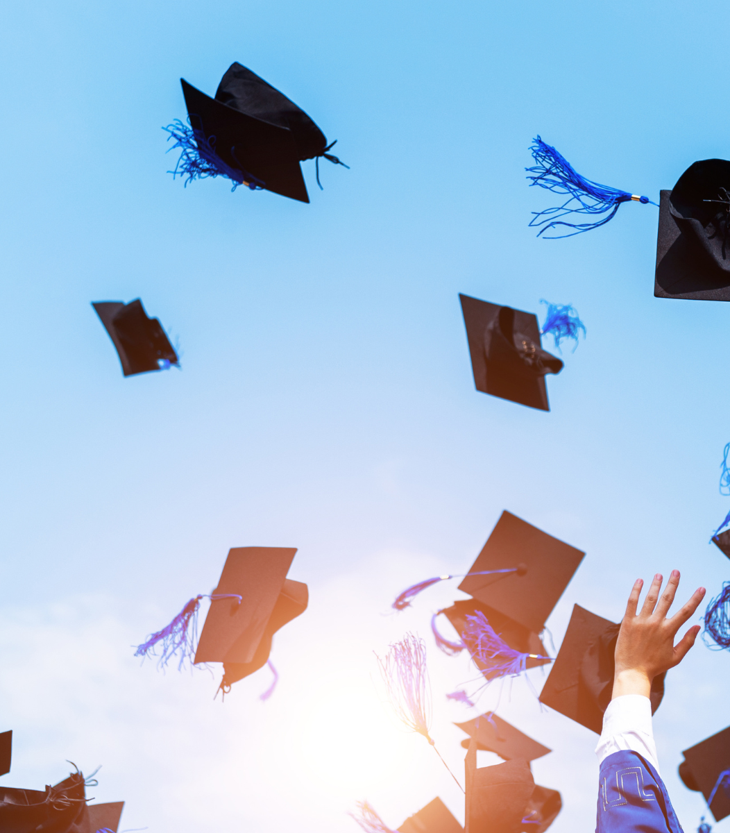 Graduation caps flying through the air in celebration