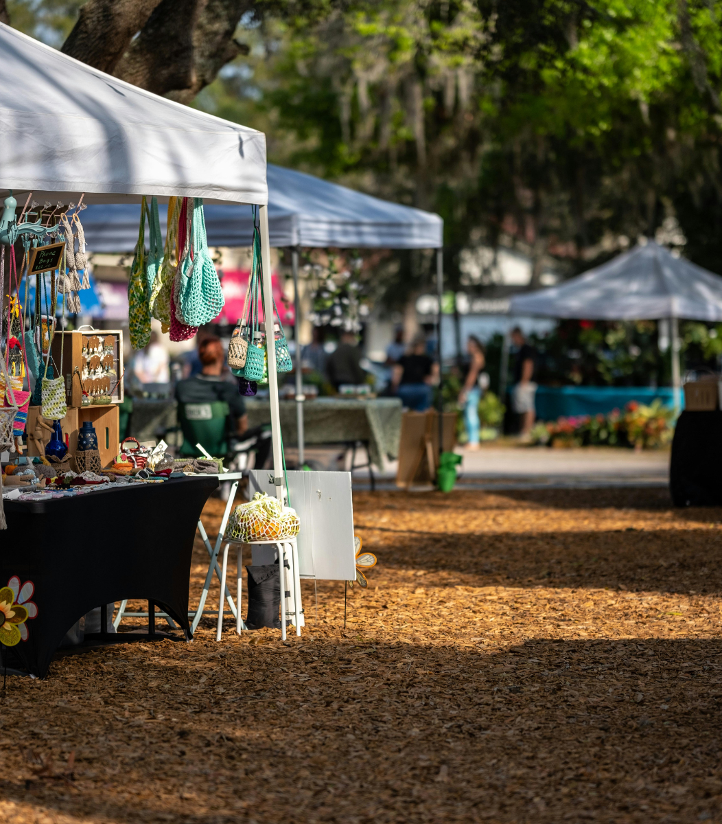 A row of vendor tents set up at a bustling vendor fair, showcasing the lively atmosphere of events organized by Cavanaugh Carriages