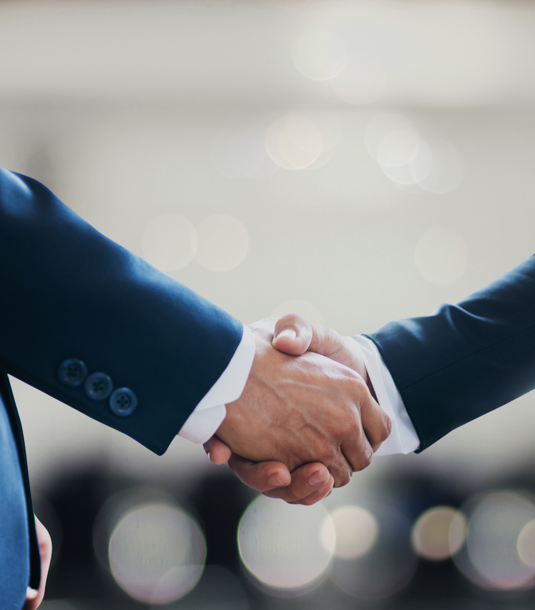 Two individuals shaking hands, symbolizing professionalism and collaboration at corporate events hosted by Cavanaugh Carriages